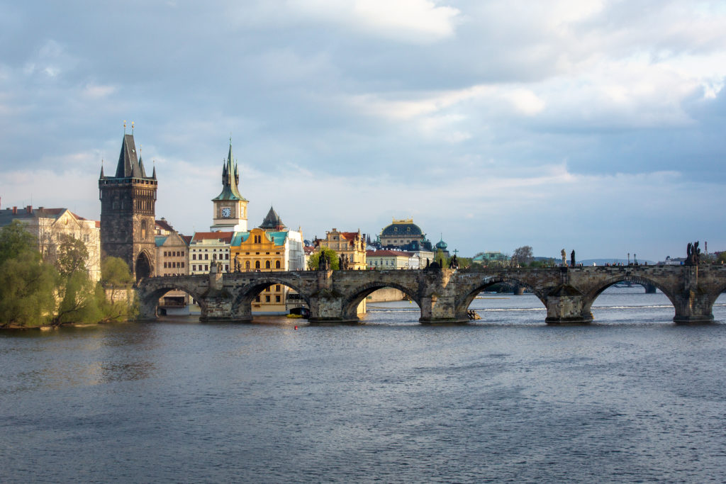 Blick auf die Karlsbrücke und Altstadt vom Ufer der Moldau bei bewölktem Himmel