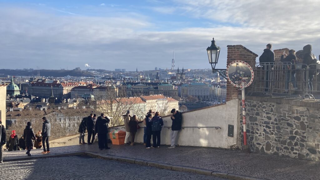 a group of people standing on a ledge overlooking a city
