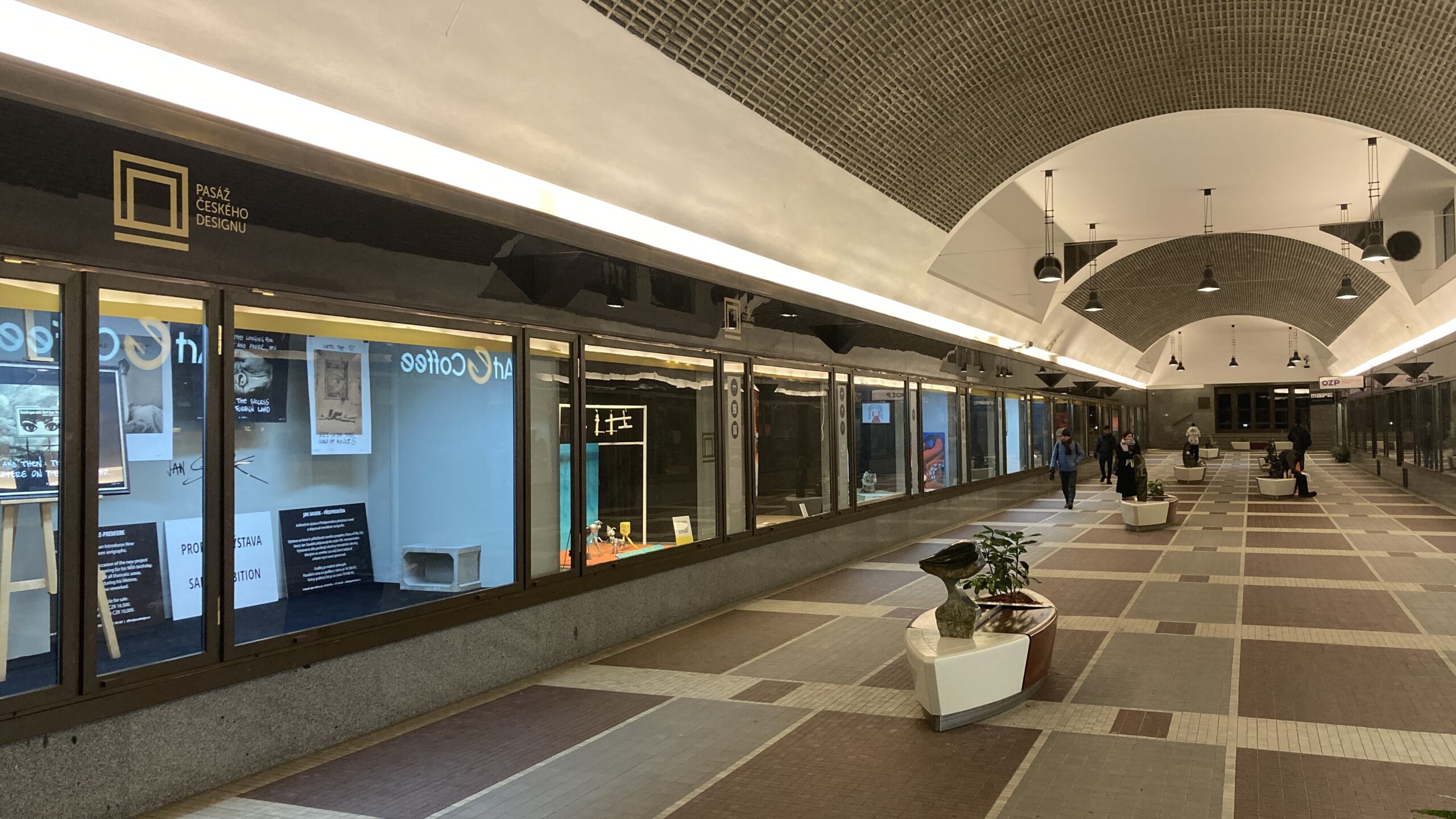a long corridor with windows and people walking