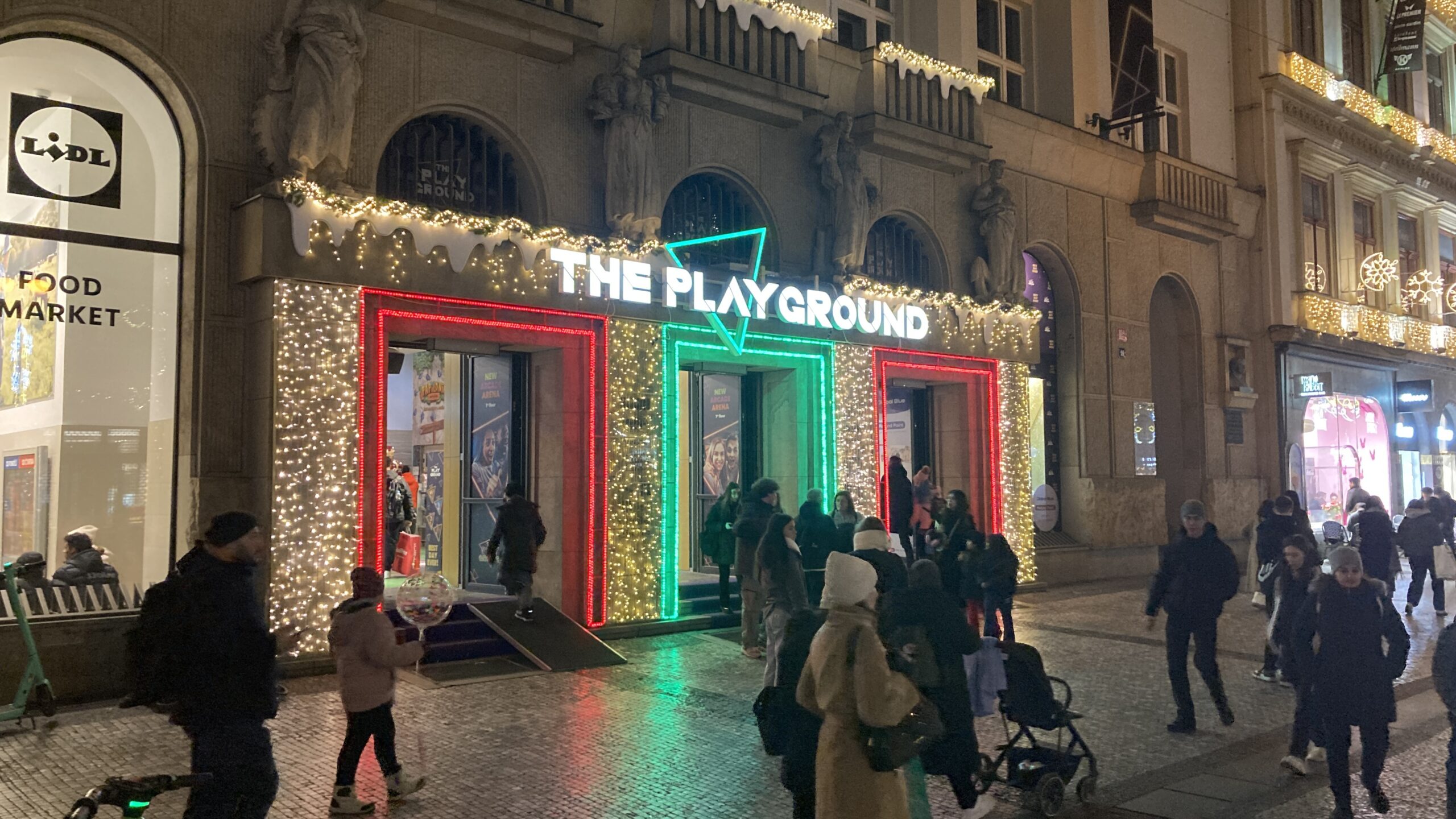 a group of people outside of a building with lights
