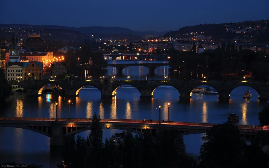 Nachtpanorama der Moldau mit mehreren Brücken und beleuchteten Uferbereichen