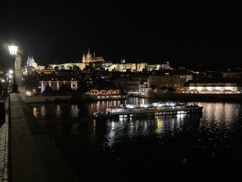 Prager Burg und Moldau in der Nacht mit hellen Reflexionen