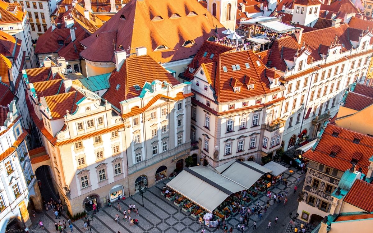 Blick von oben auf den Altstädter Ring in Prag mit historischen Bürgerhäusern, roten Dächern und belebtem Platz