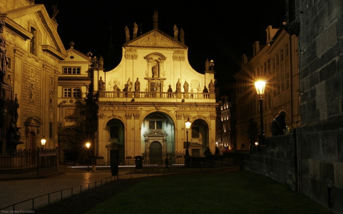 Beleuchtete Salvatorkirche in der Prager Altstadt bei Nacht mit barocker Fassade und Heiligenstatuen