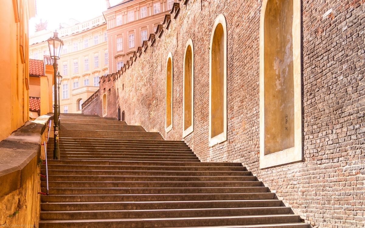Historische Schlosstreppe an der Prager Burg mit gemauerter Stadtmauer und aufsteigenden Stufen