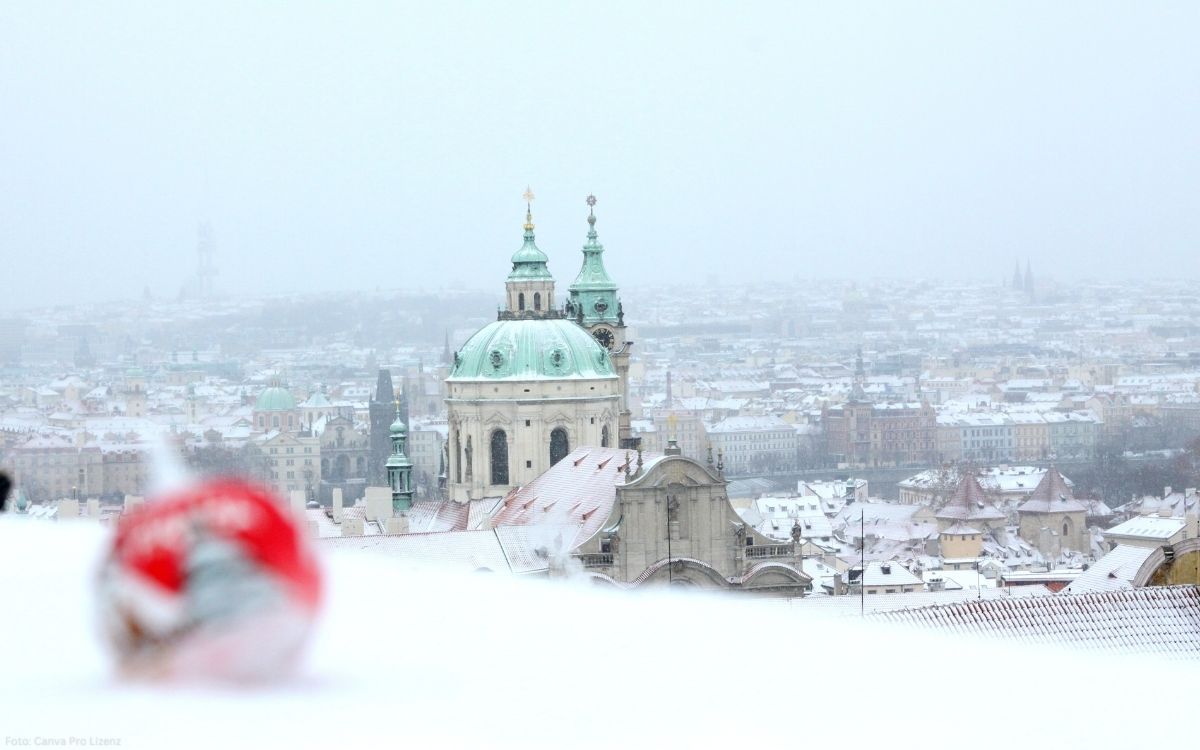 St.-Nikolaus-Kirche auf der Kleinseite mit verschneiter Prager Altstadt im Hintergrund