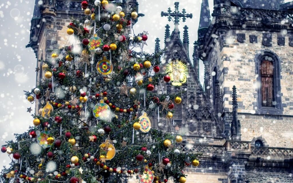 Geschmückter Weihnachtsbaum vor der Teynkirche am Altstädter Ring in Prag bei winterlichem Schneefall