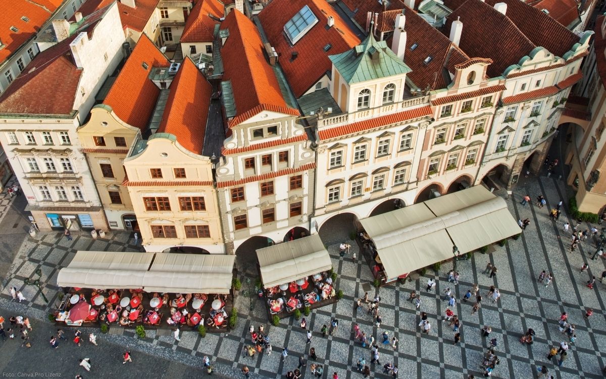 Blick von oben auf historische Häuser und Arkaden in der Prager Altstadt