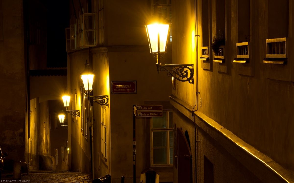 Schmale Gasse auf der Prager Kleinseite bei Nacht mit historischen Gaslaternen und warmem Licht