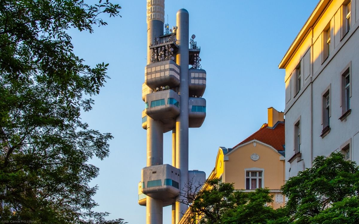 Blick auf den Fernsehturm im Stadtteil Žižkov mit Wohnhäusern und Bäumen im warmen Abendlicht