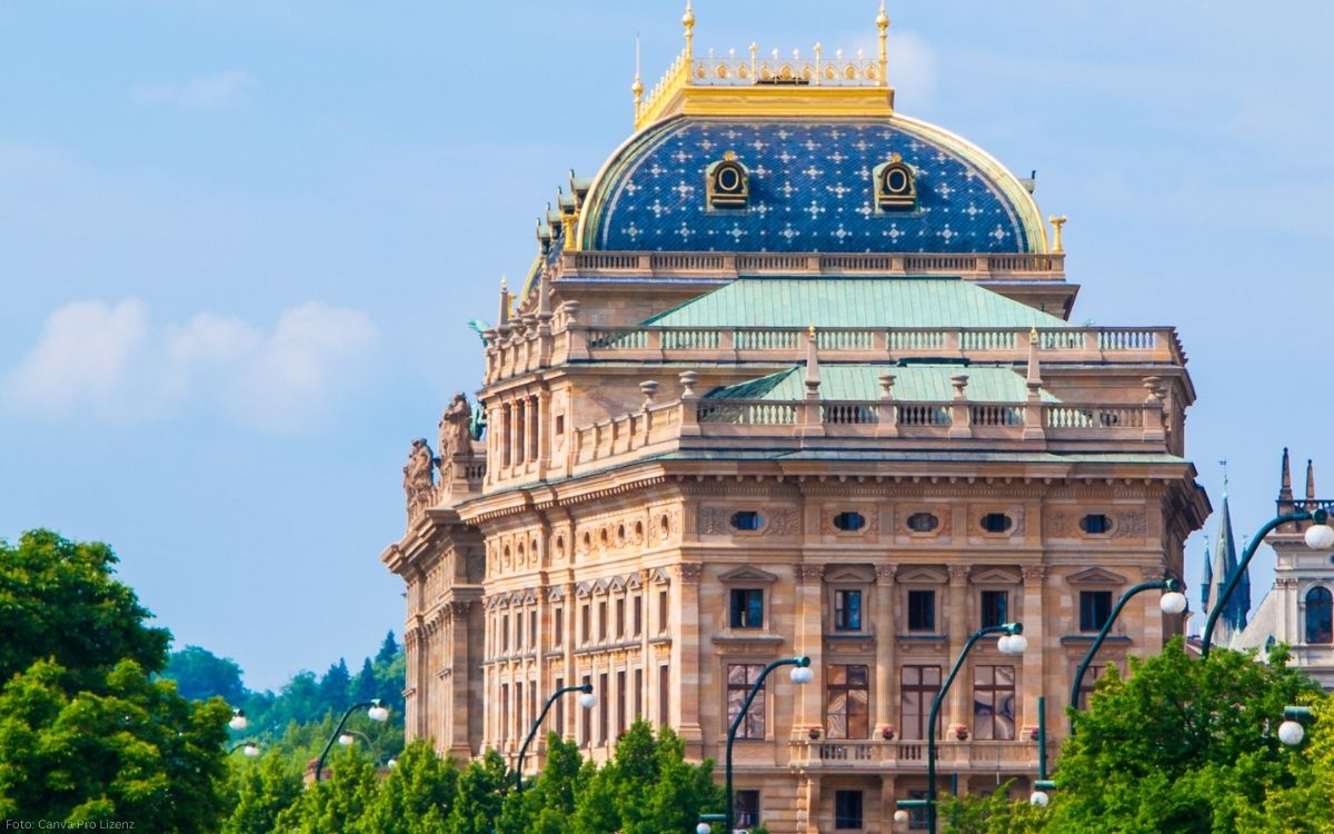 Ansicht des Prager Nationaltheaters mit reich verzierter Fassade und markanter Kuppel bei Tageslicht