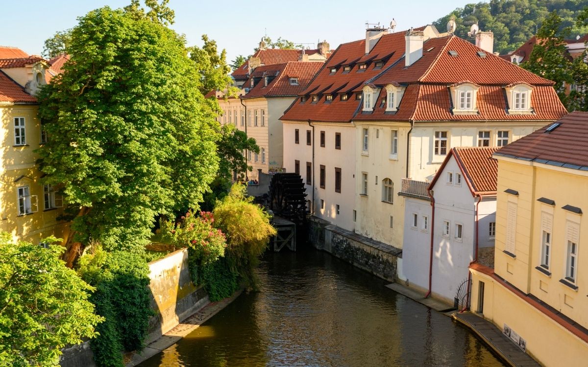 Blick auf den Teufelskanal in Prag mit historischen Häusern, rotem Ziegeldach und ruhigem Wasserlauf