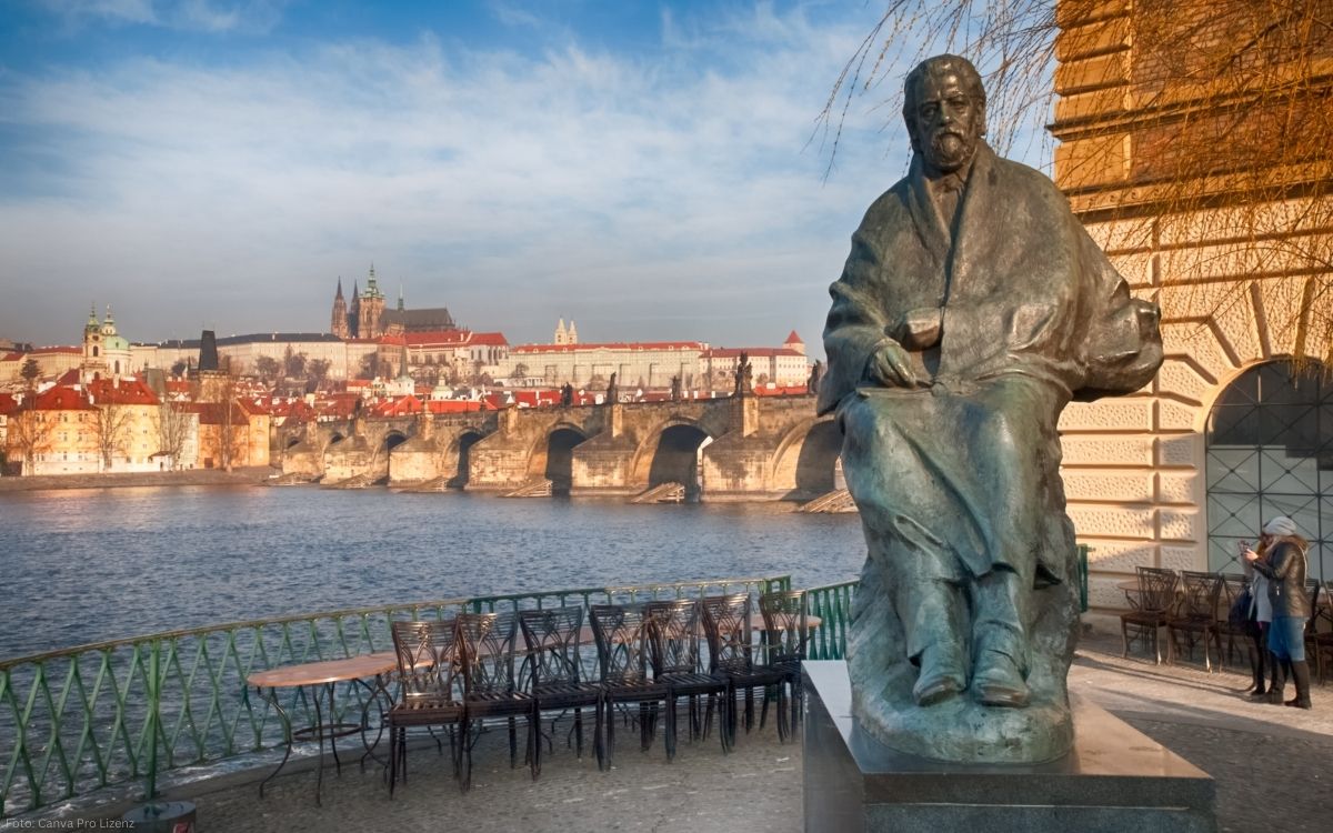 Statue von Bedřich Smetana an der Moldau mit Blick auf die Karlsbrücke und die Prager Burg