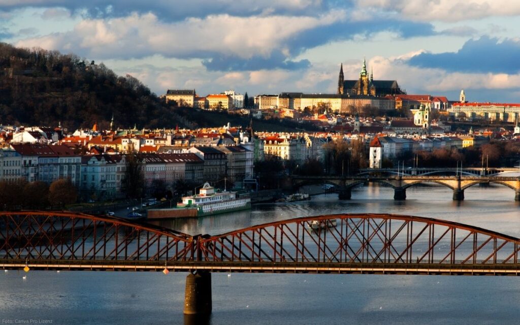 Panoramablick auf Prag mit Moldau, Eisenbahnbrücke und der Prager Burg im Hintergrund