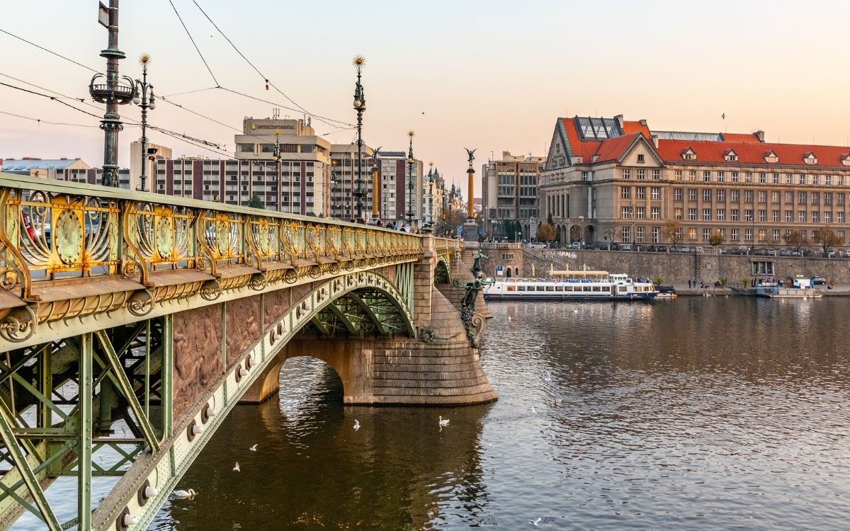 Čech-Brücke in Prag mit Blick über die Moldau und historische Uferbebauung in der Abendstimmung