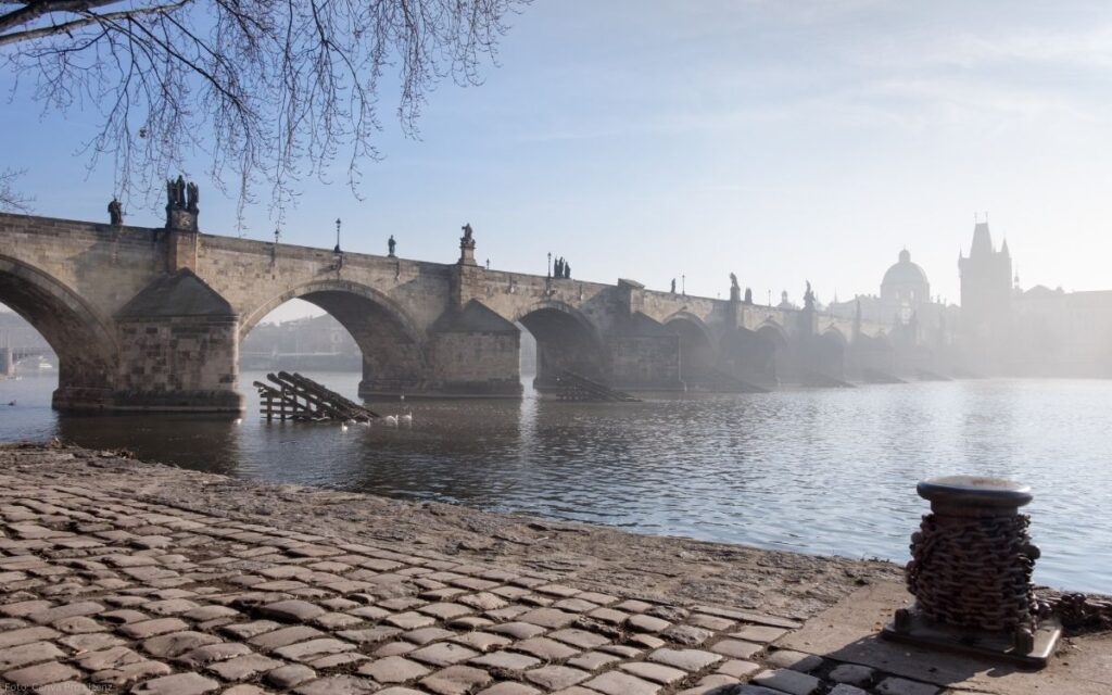 Karlsbrücke in Prag im morgendlichen Dunst mit Blick über die Moldau und die Altstadt