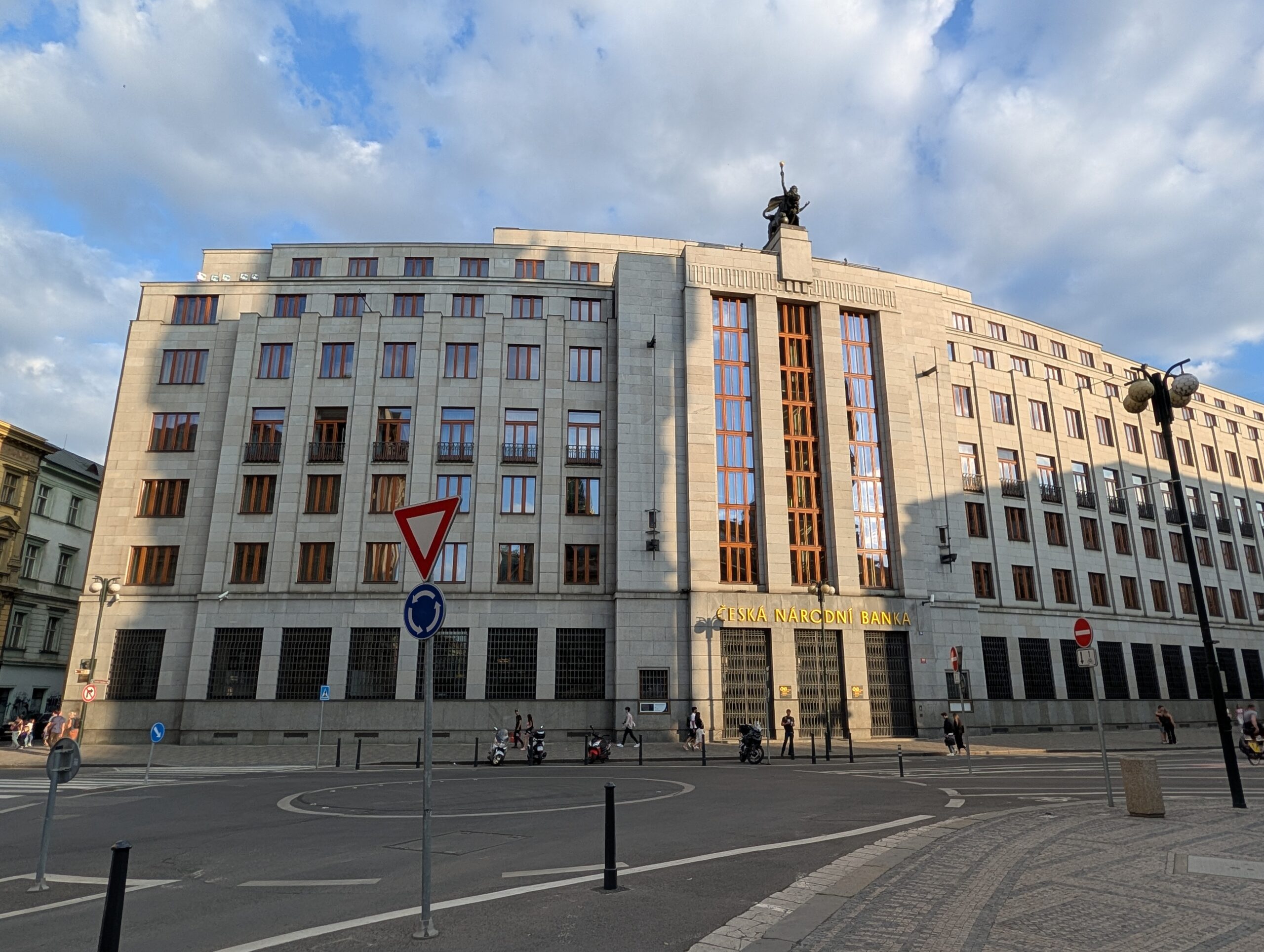 Tschechische Nationalbank in Prag mit monumentaler Steinfassade, hohem Eingangsportal und goldfarbenem Schriftzug