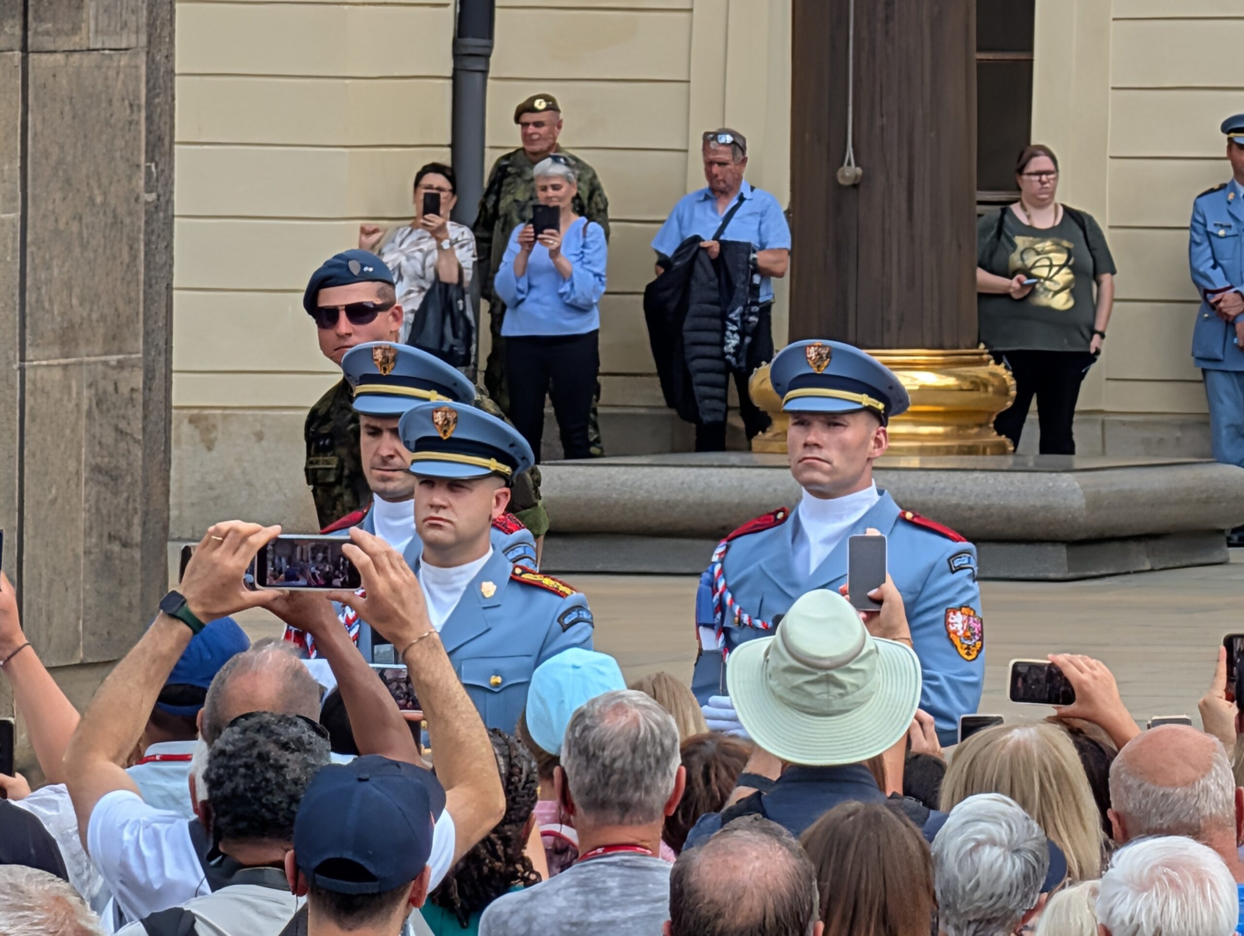 Soldaten der Burgwache in hellblauen Uniformen bei der Wachablösung vor zahlreichen Besuchern an der Prager Burg