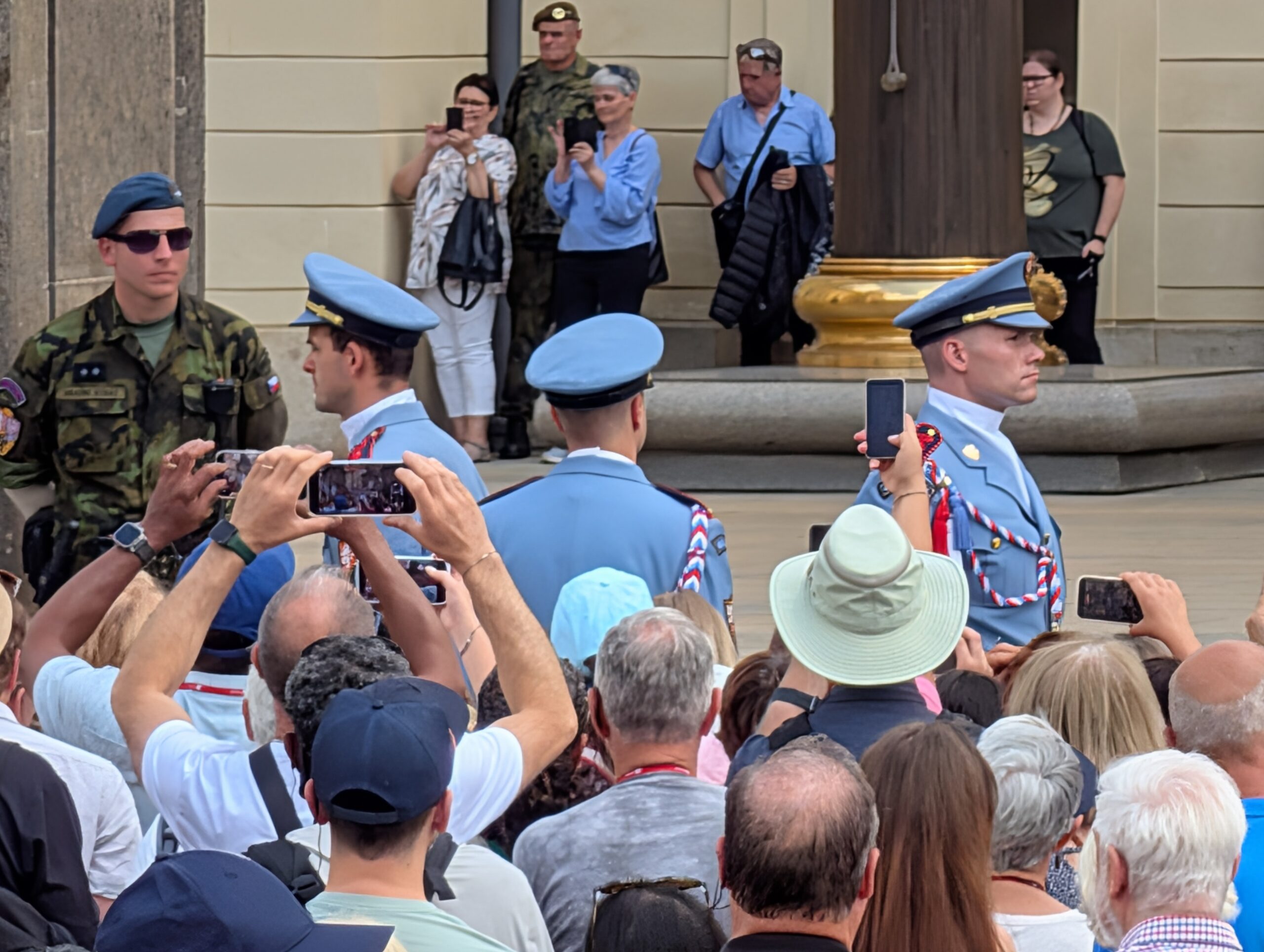 Soldaten der Burgwache in hellblauen Uniformen bei der Wachablösung vor zahlreichen Besuchern an der Prager Burg