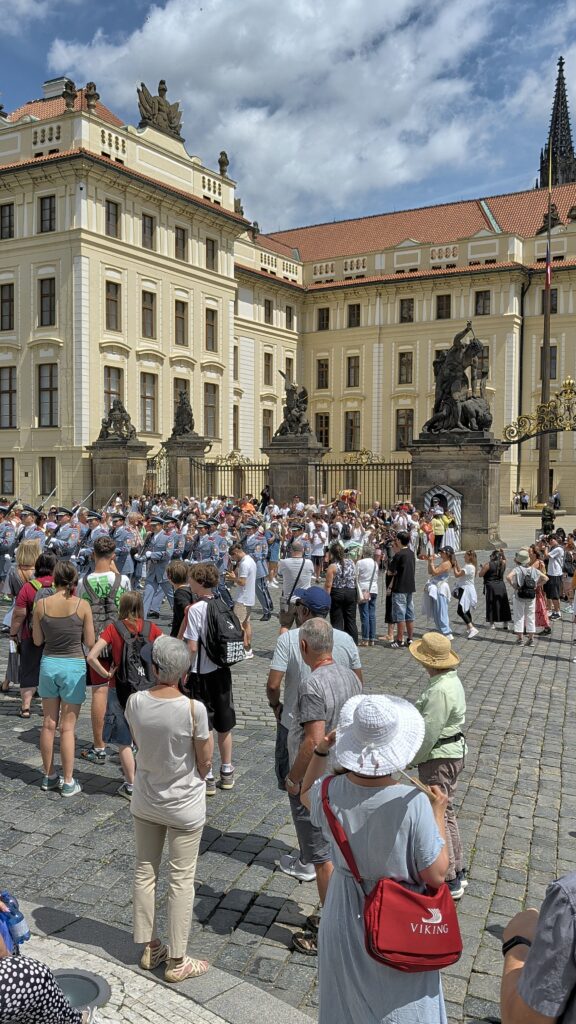 Soldaten der Burgwache bei der Wachablösung vor dem Tor der Giganten und zahlreichen Besuchern an der Prager Burg