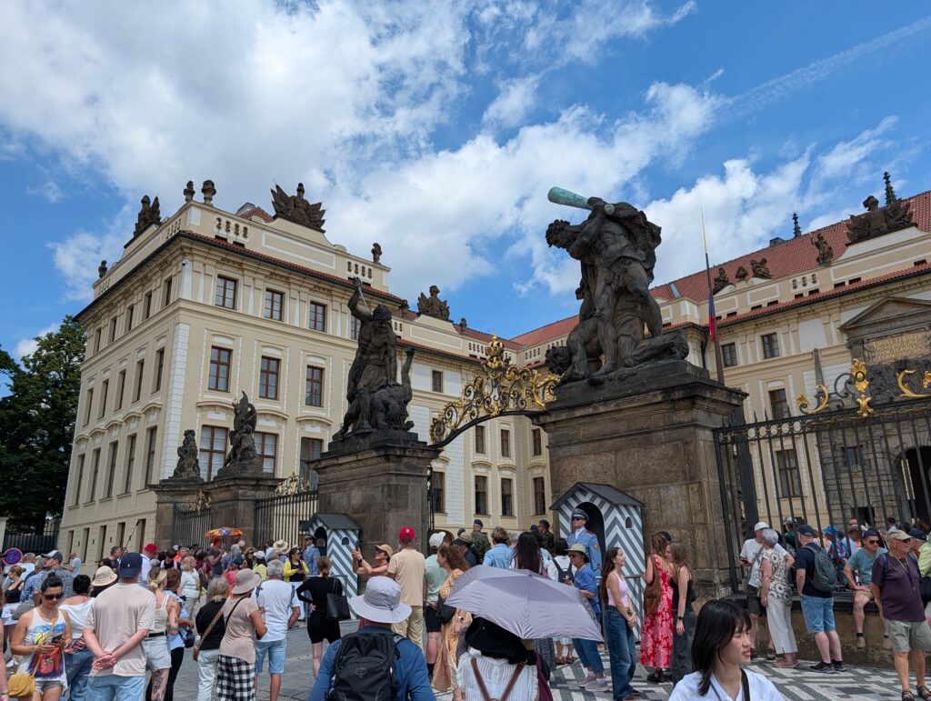 Tor der Giganten an der Prager Burg mit monumentalen Statuen, Wachhäuschen und zahlreichen Besuchern