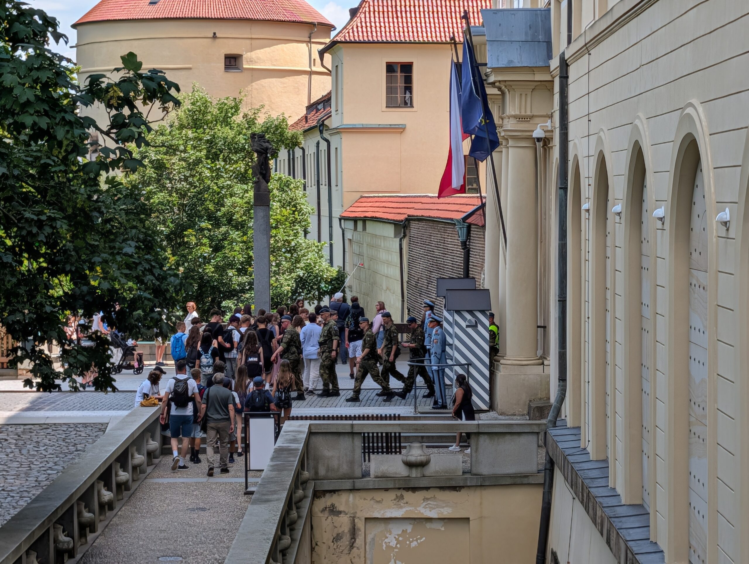 Besucher am kontrollierten Eingang der Prager Burg mit Burgwache, Sicherheitskräften und tschechischer Flagge