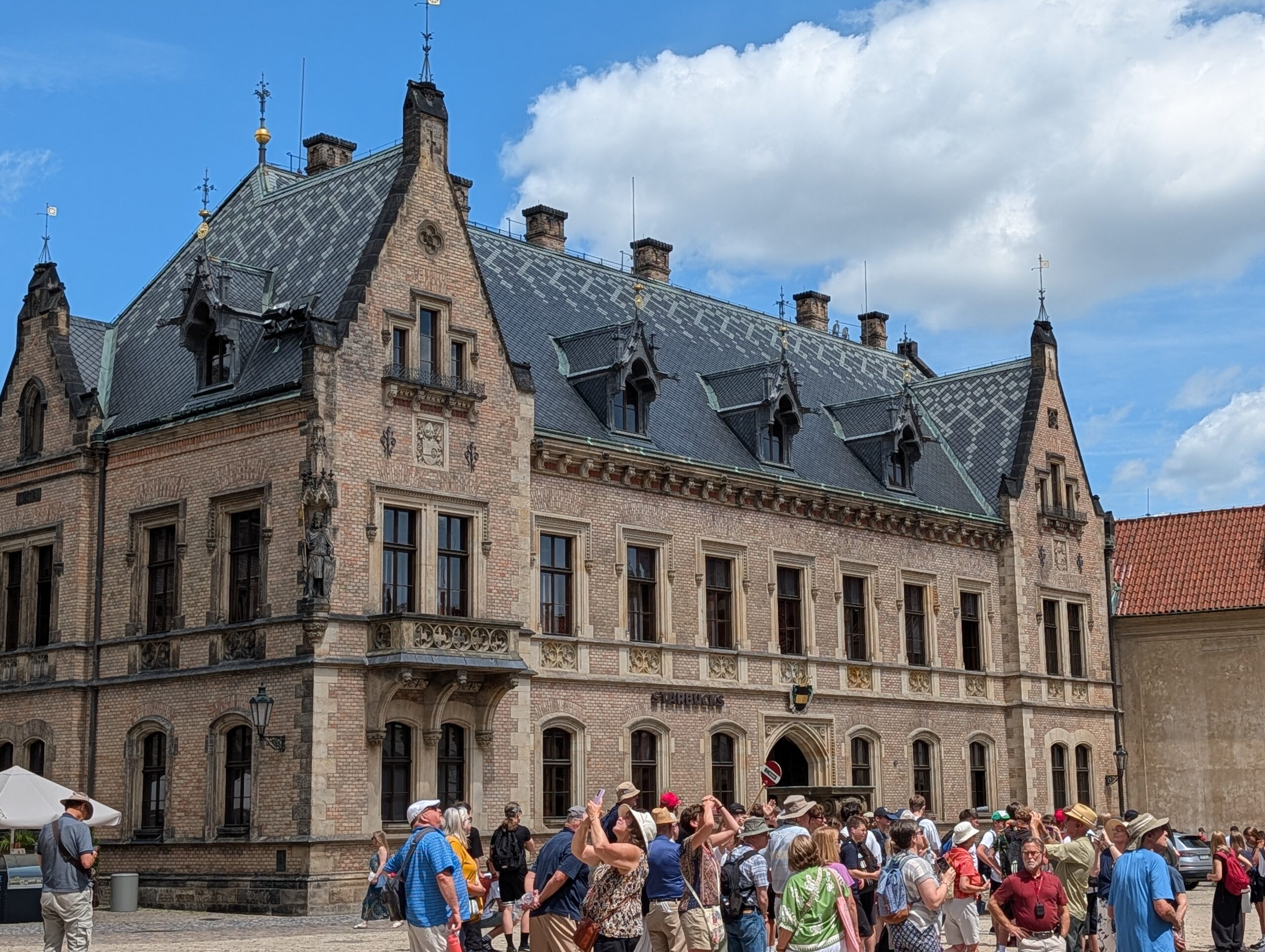 Neue Propstei auf der Prager Burg mit neugotischer Fassade, Schieferdach und Besuchern am Georgsplatz