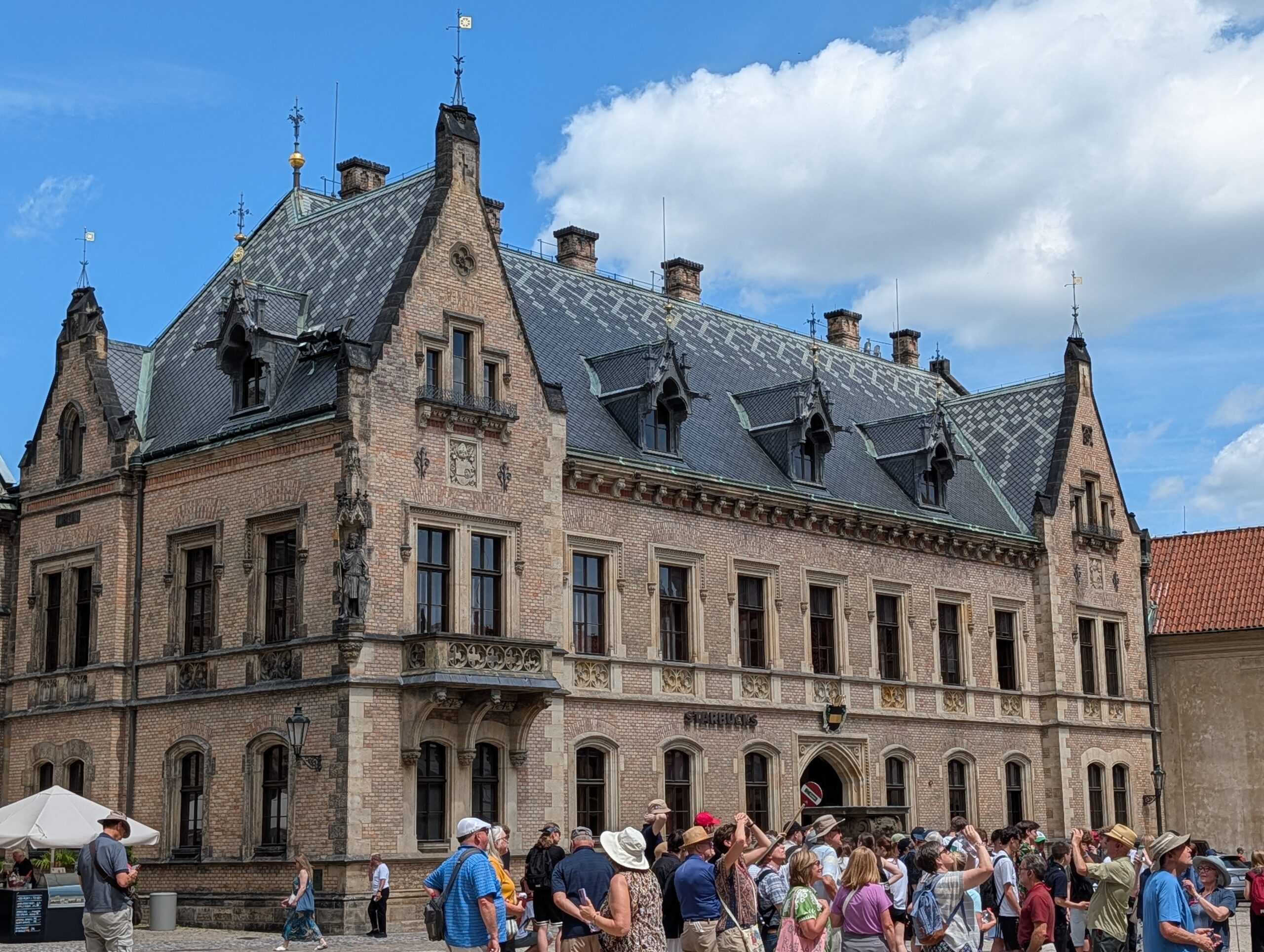 Neue Propstei auf der Prager Burg mit neugotischer Fassade, Schieferdach und Besuchern am Georgsplatz