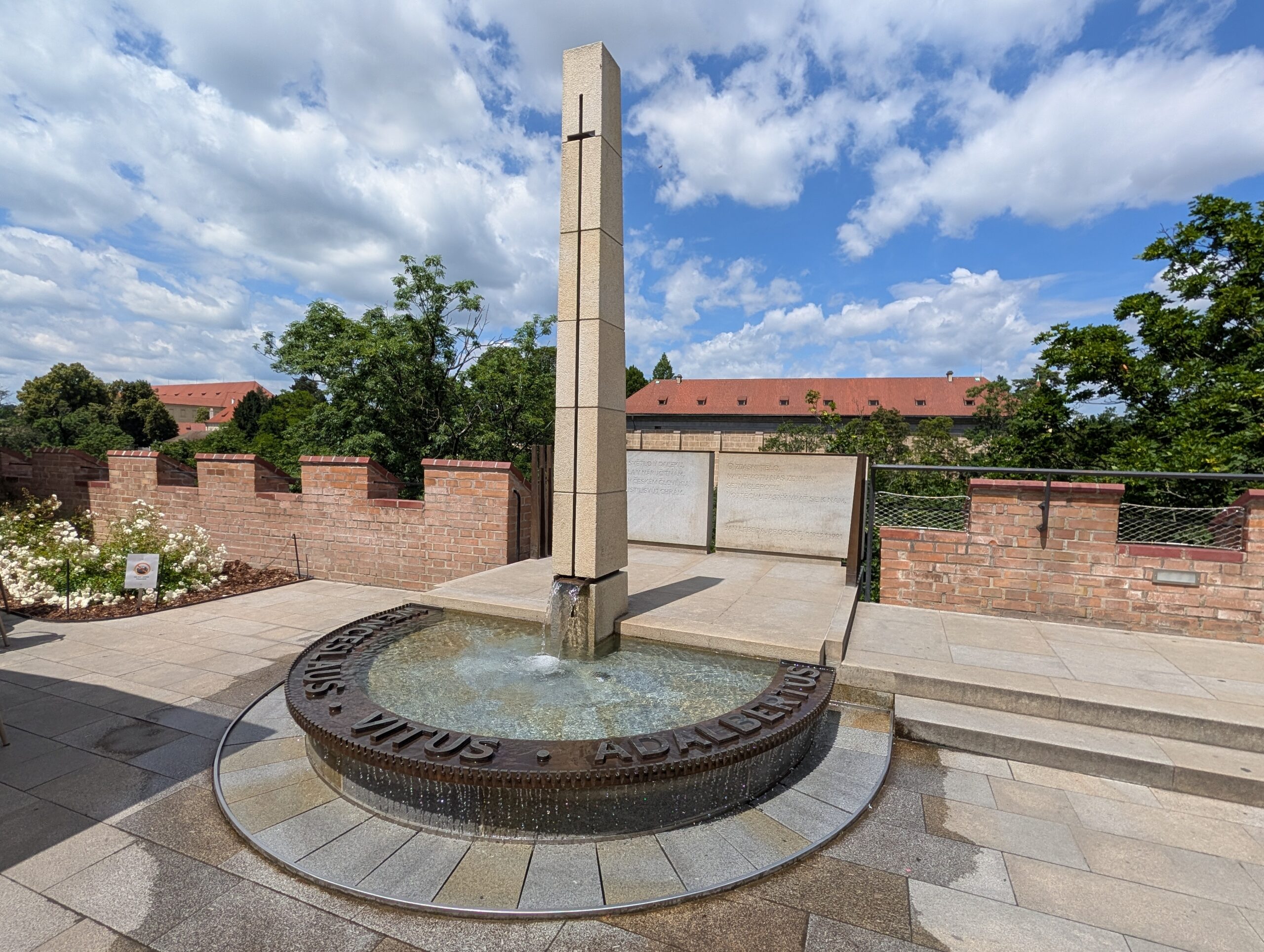 Steinerner Obelisk mit Kreuz in einem runden Brunnen in den Südlichen Gärten der Prager Burg