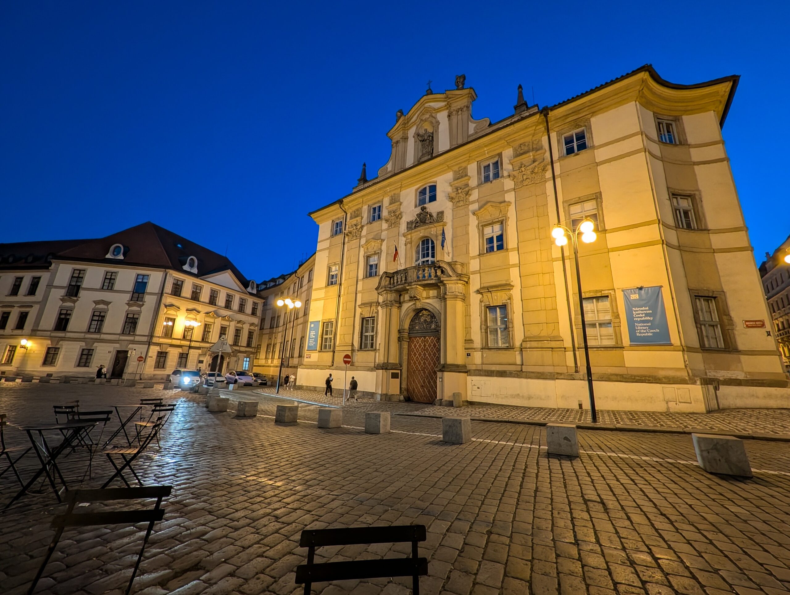 Marienplatz in Prag bei Nacht mit beleuchtetem barockem Gebäudeflügel des Klementinums