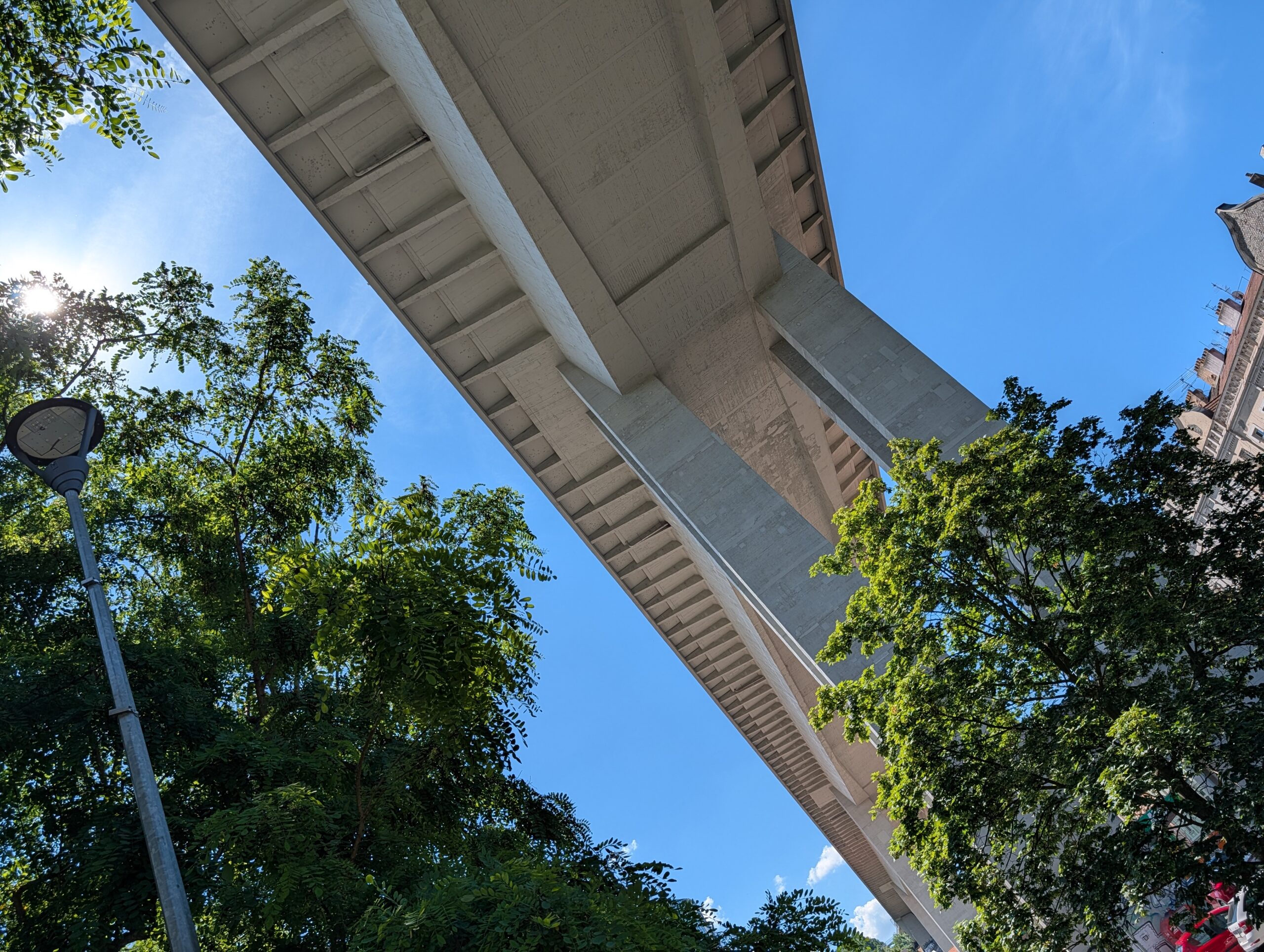 Unterseite der Nusle-Brücke in Prag mit Betonpfeilern und Bäumen im Park Folimanka