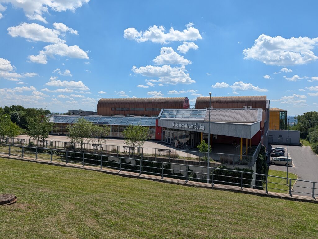 Panoramablick auf das Aquacentrum Šutka mit Hallenbad und Freibad in Prag.