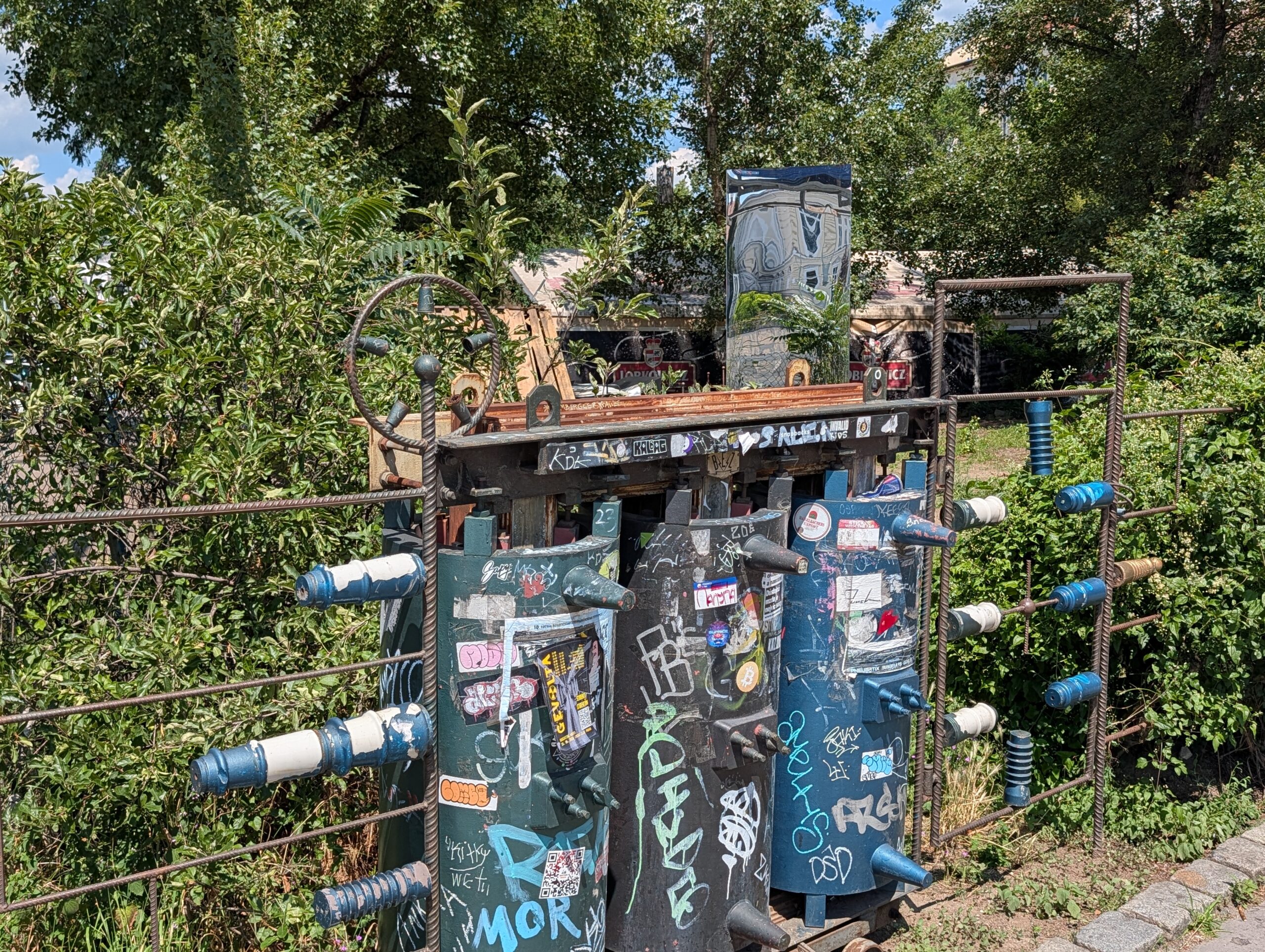 Steampunk-Installation mit bemalten Schaltschränken, Metallrohren und Graffiti im Außenbereich des Cross Club in Prag-Holešovice.