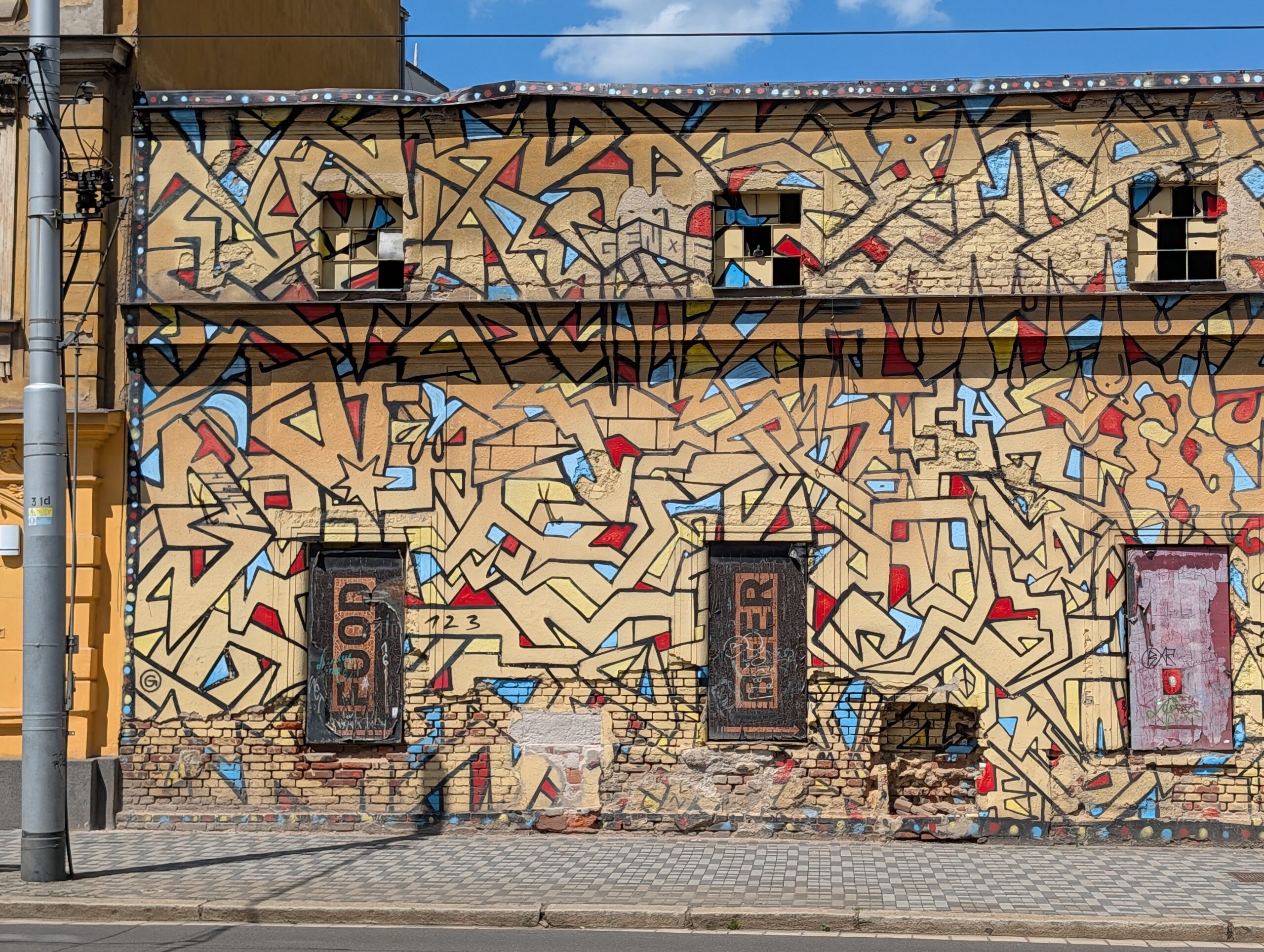 Großflächiges Street-Art-Wandgemälde an einer Hausfassade im Prager Stadtteil Holešovice.