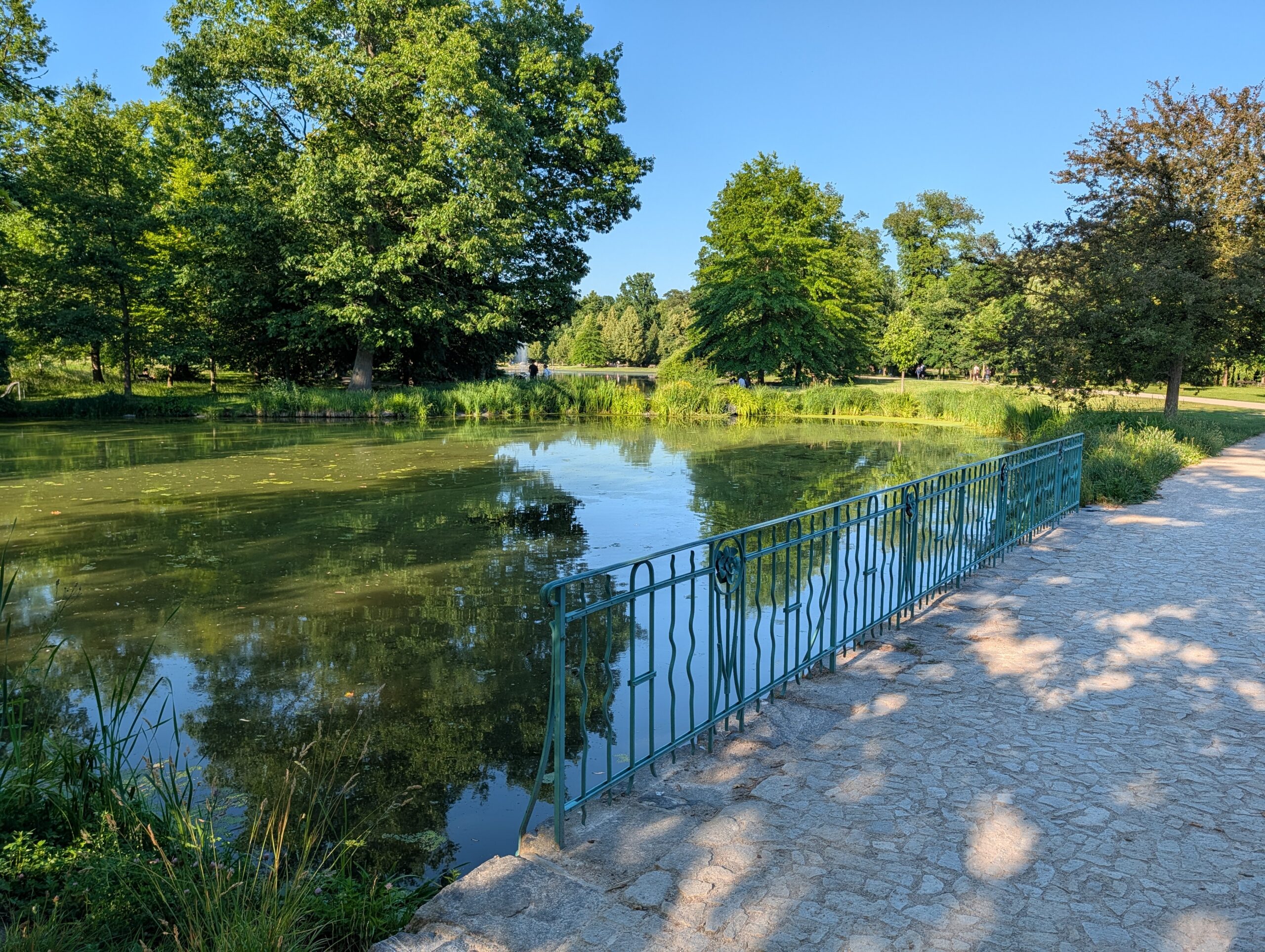 Uferweg mit Geländer am Parkteich im Königlichen Wildpark Stromovka (Královská obora Stromovka) in Prag.