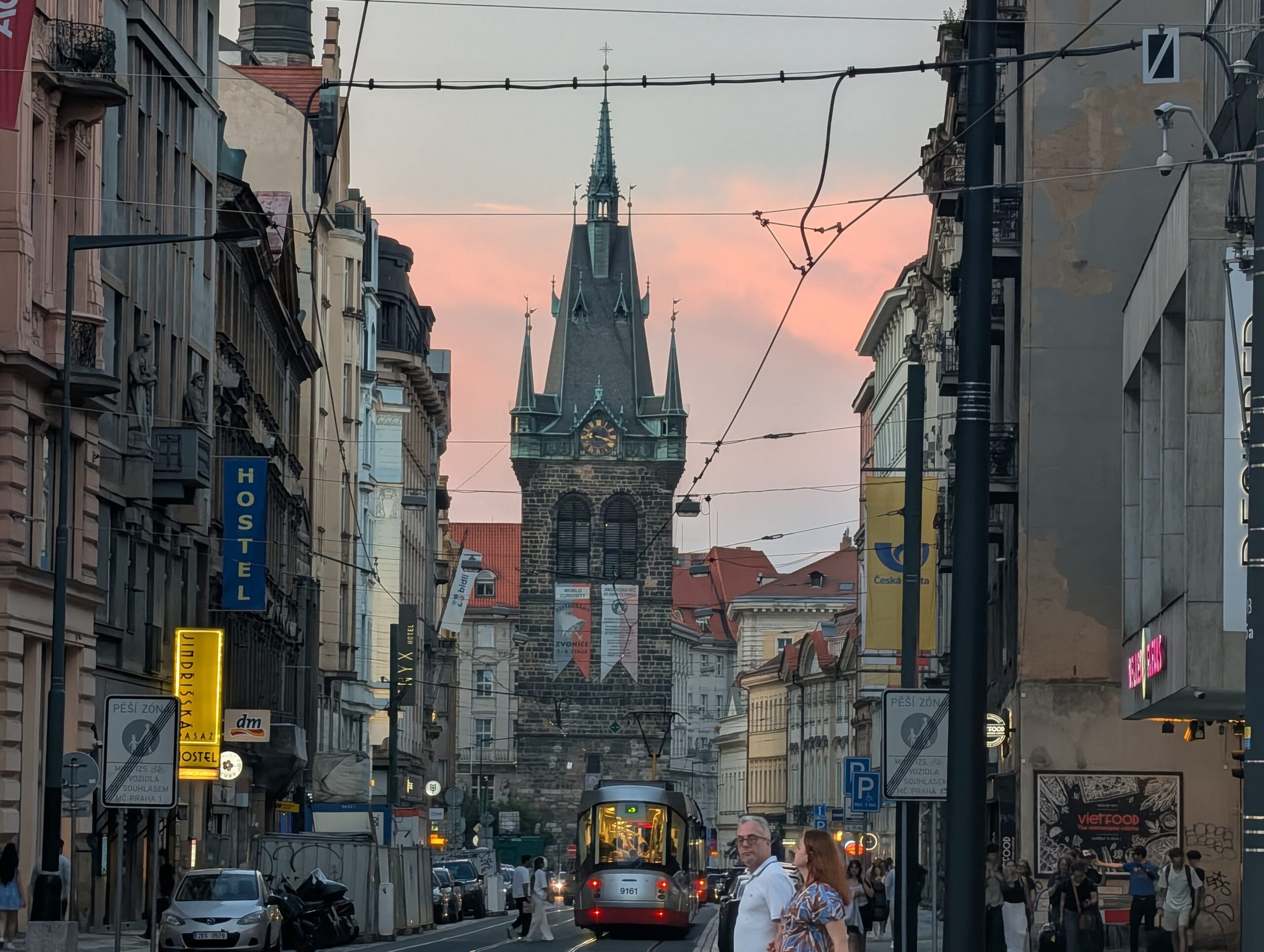 Blick auf den Heinrichsturm (Jindřišská věž) in der Prager Neustadt mit Straßenbahn und Abendhimmel.
