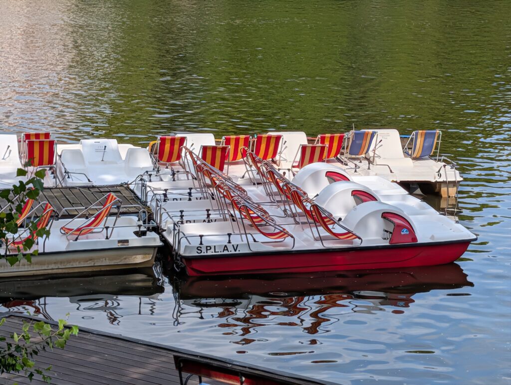 Weiße und rote Tretboote am Steg des Bootsverleihs S.P.L.A.V. in Prag