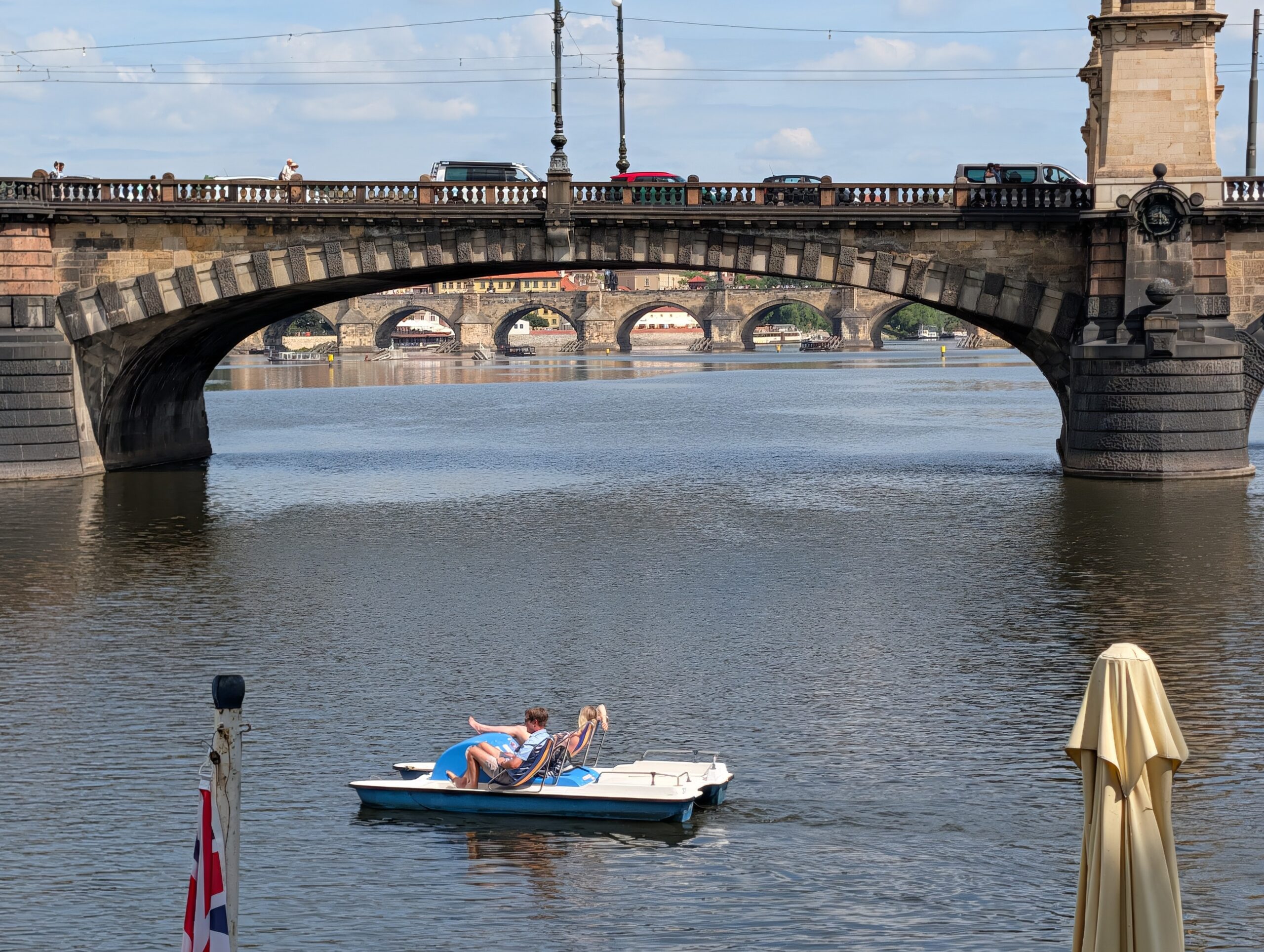 Zwei Personen in einem Tretboot auf der Moldau vor der Brücke der Legionen in Prag