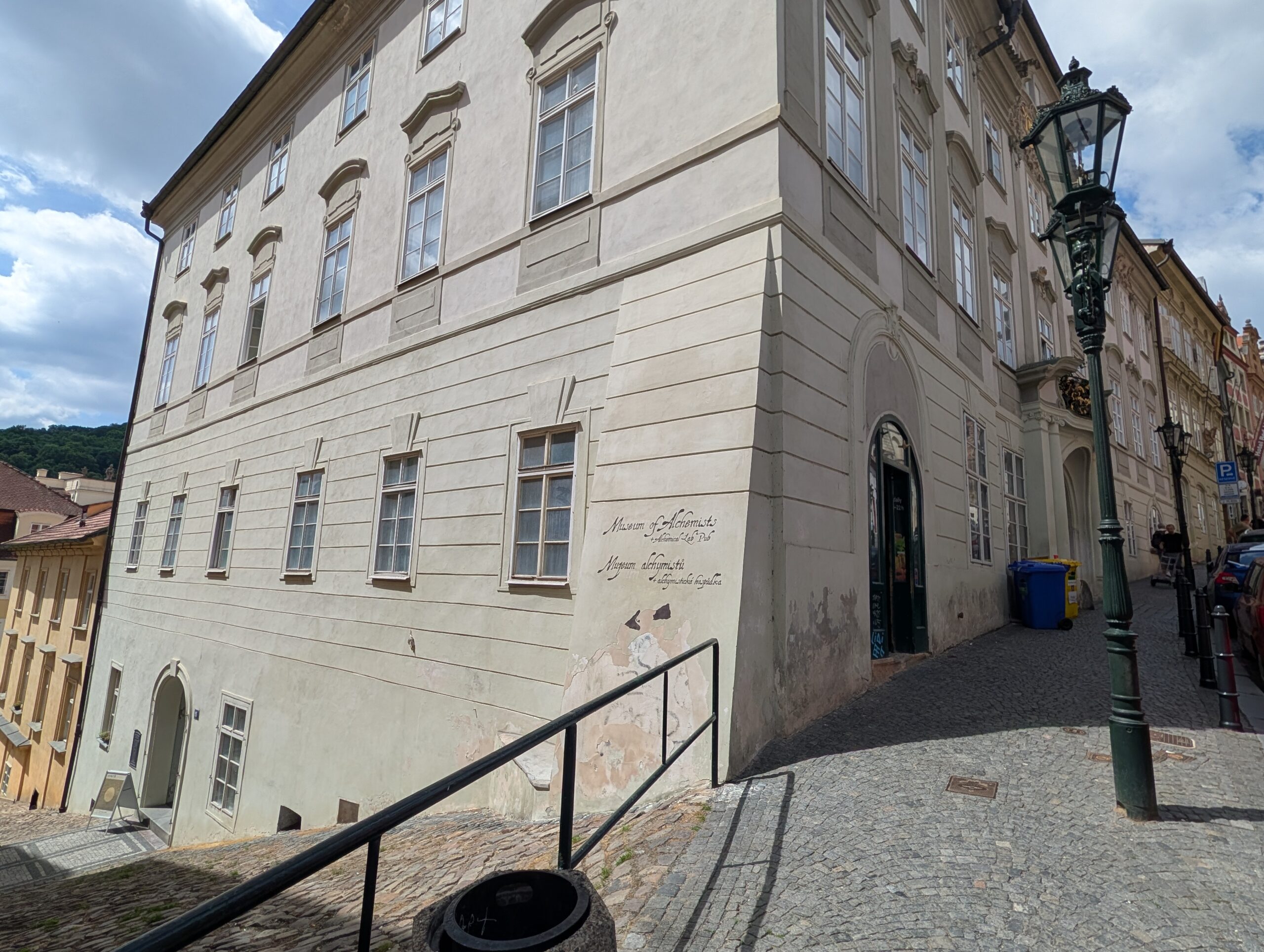 Helles historisches Eckgebäude an einer steilen gepflasterten Gasse auf der Prager Kleinseite