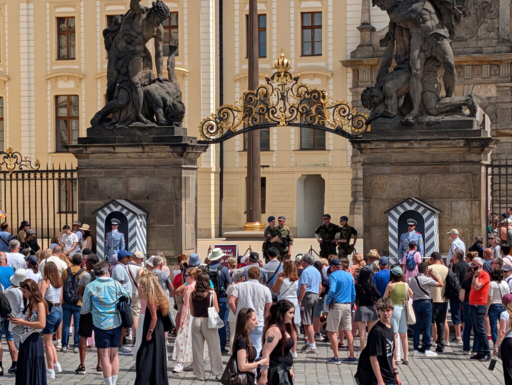 Matthiastor der Prager Burg mit barocken Statuen, Burgwache und zahlreichen Besuchern