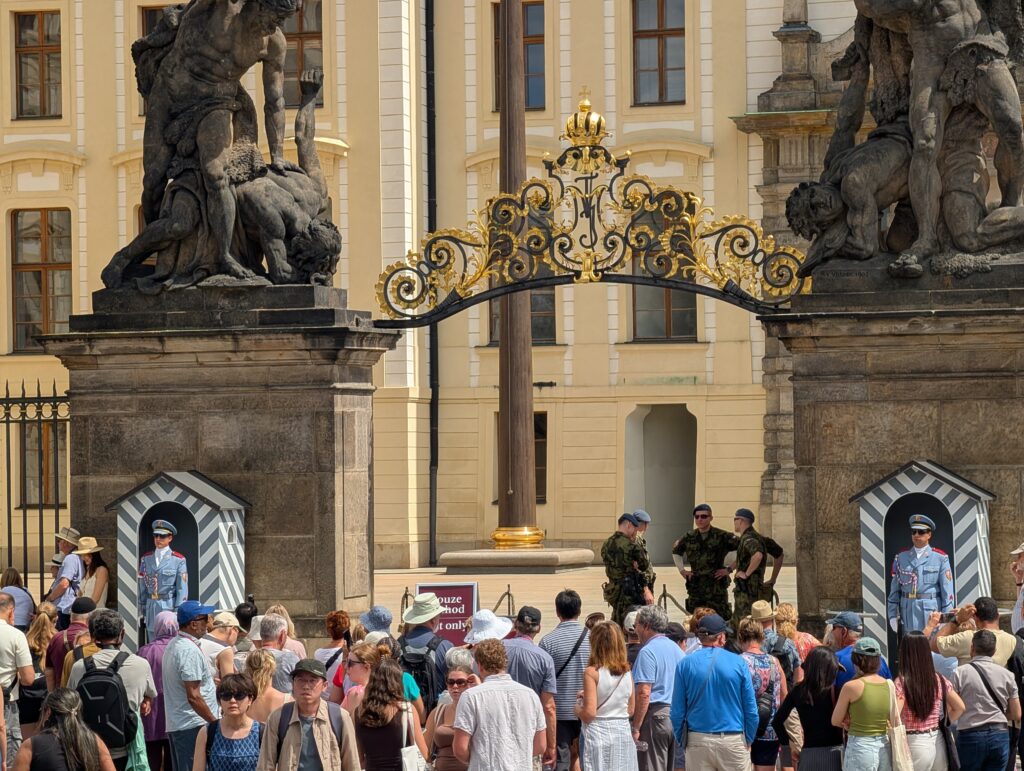 Haupteingang zur Prager Burg mit barocken Statuen, Burgwache und zahlreichen Besuchern