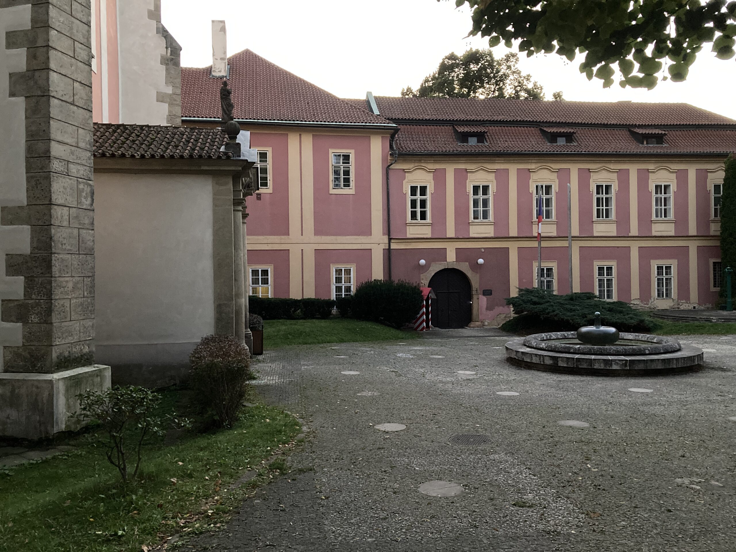 Innenhof des ehemaligen Augustinerklosters auf dem Karlshof in Prag mit rosafarbener Fassade und Brunnen