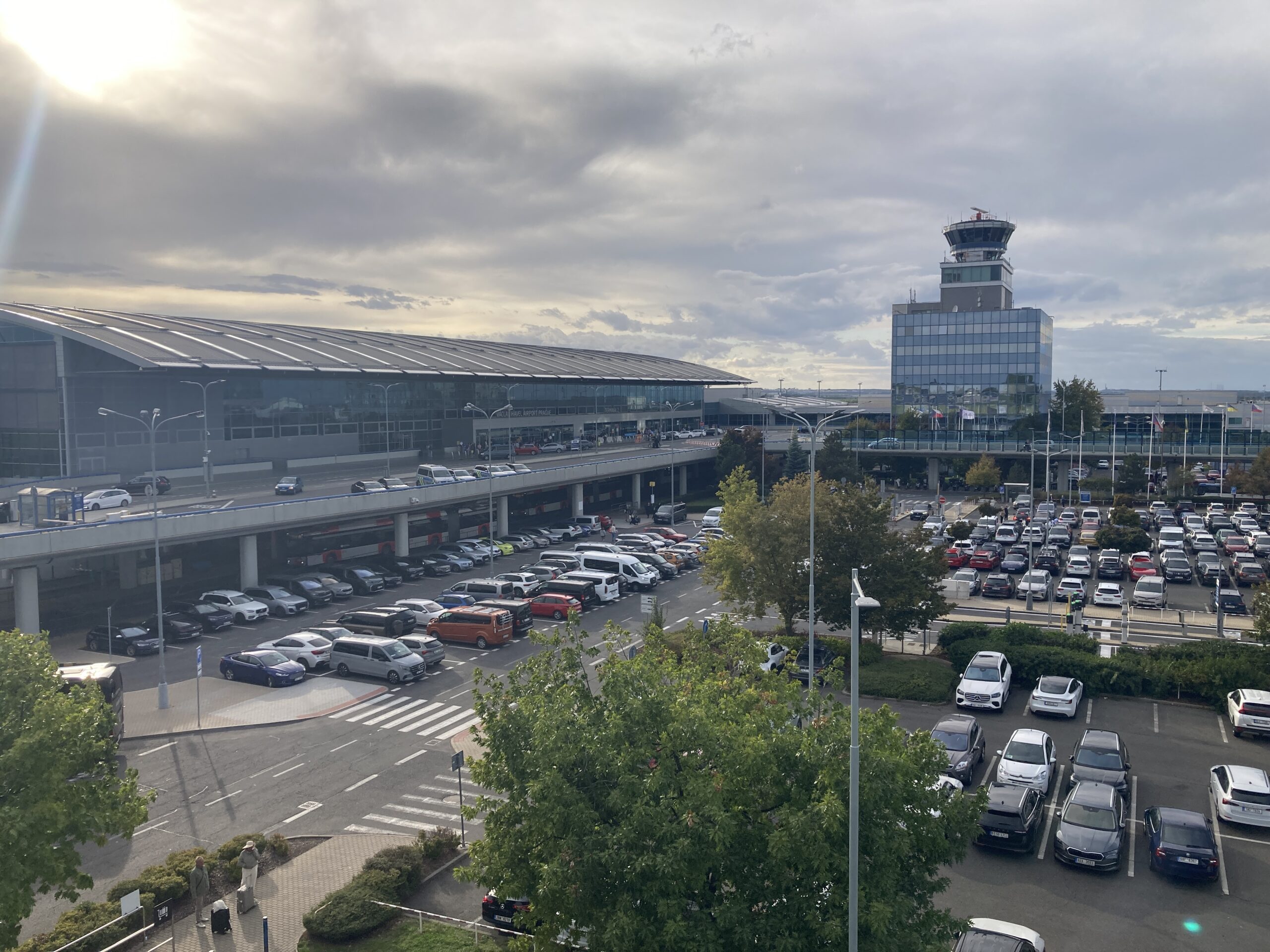 Václav-Havel-Flughafen Prag mit Terminalgebäude, Kontrollturm, Zufahrtsstraßen und Parkflächen.