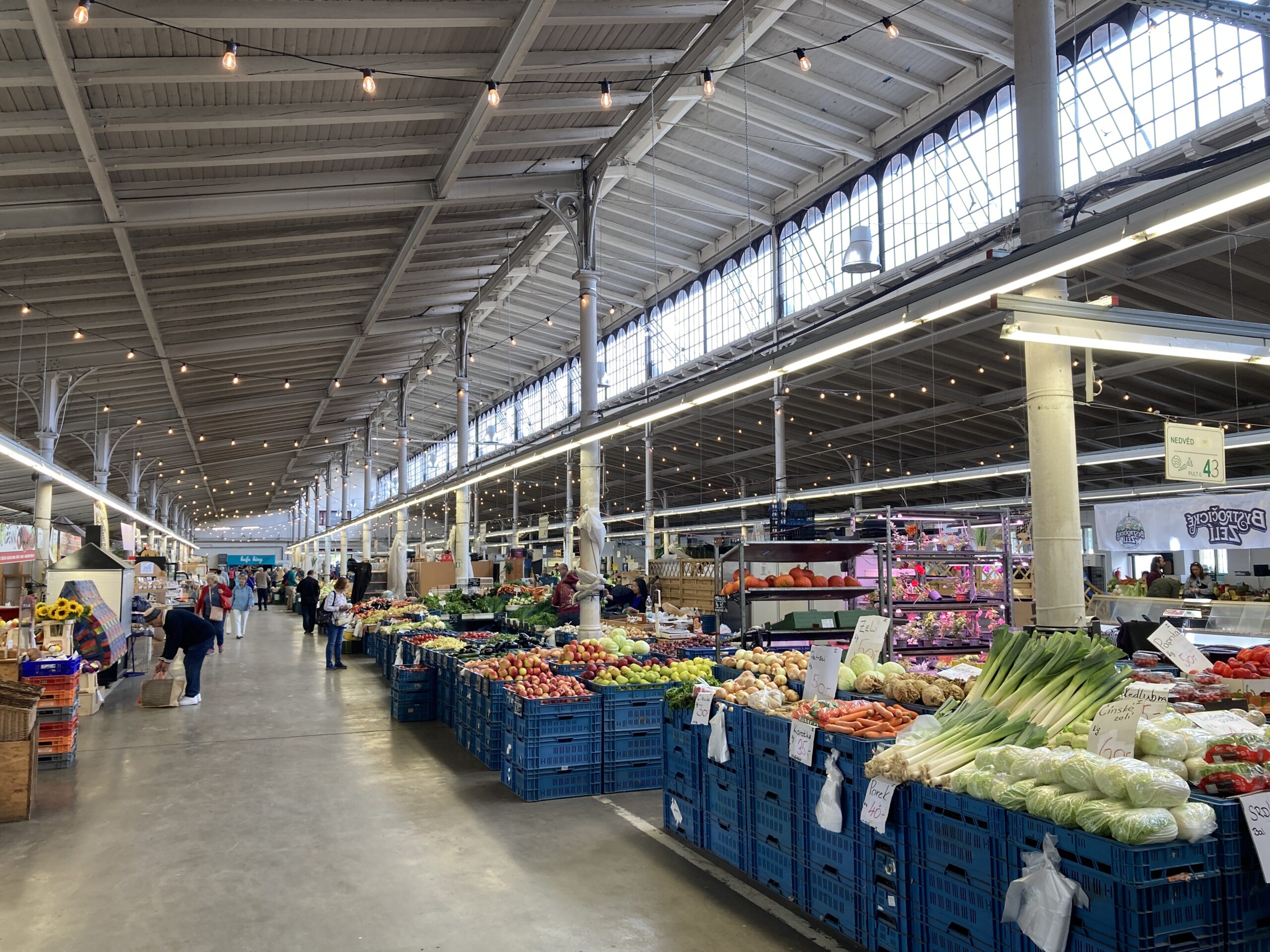 Markthalle des Holešovice-Markts in Prag mit zahlreichen Ständen für Obst und Gemüse.