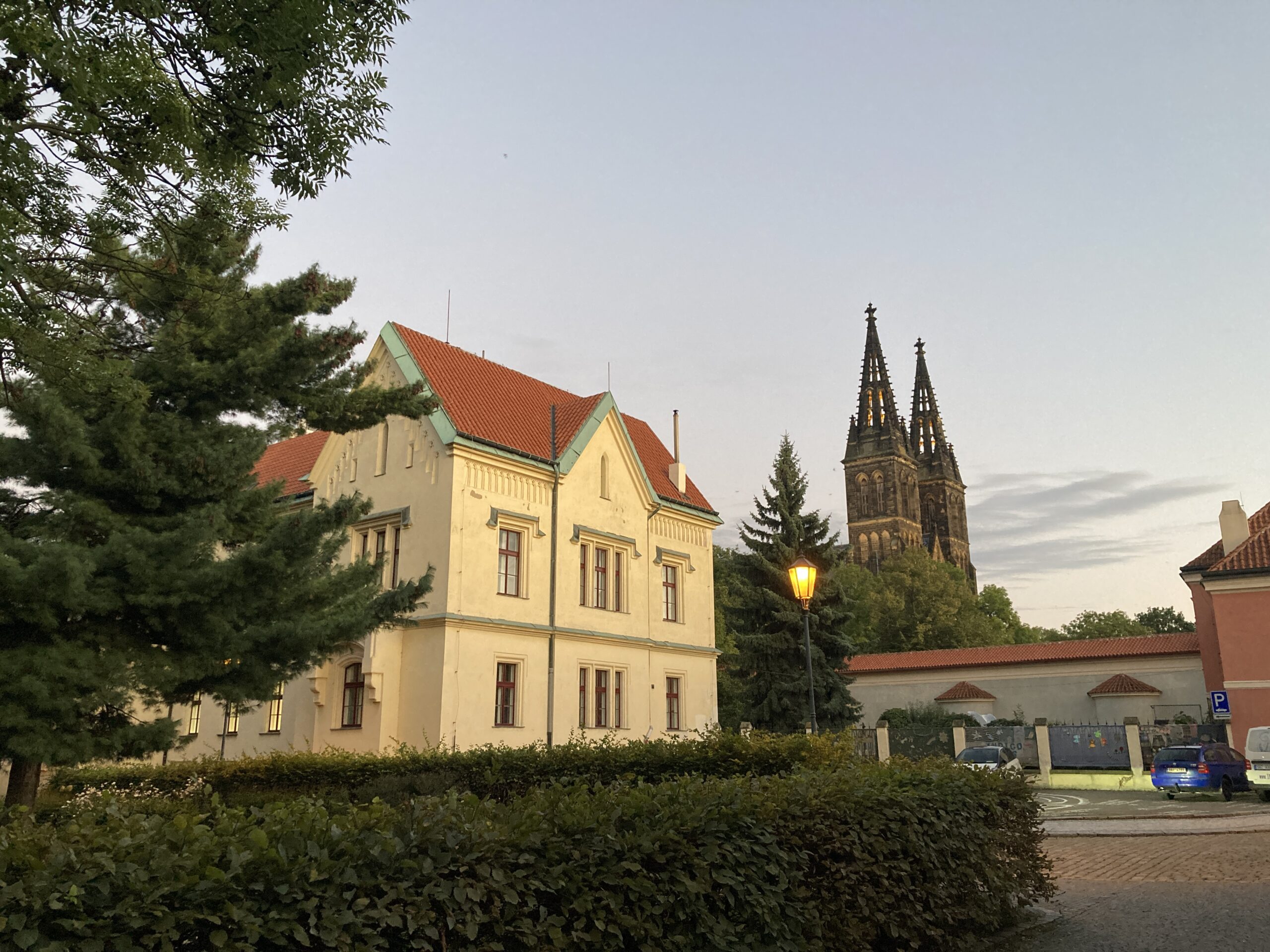 Türme der St.-Peter-und-Paul-Basilika zwischen Gebäuden und Bäumen am Vyšehrad in Prag