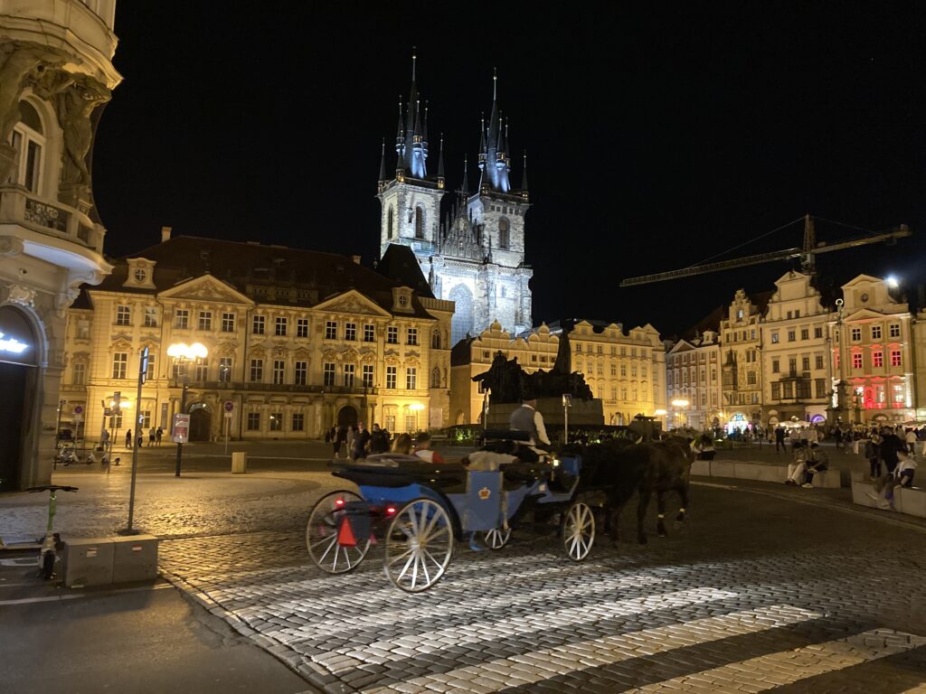 Pferdekutsche am Altstädter Ring in Prag mit beleuchteter Teynkirche bei Nacht