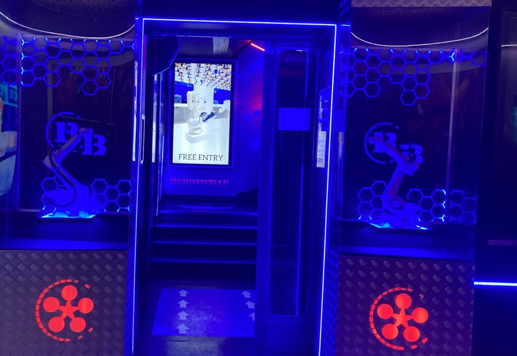 Blau beleuchteter Eingang mit Glastür zum Ice Pub in Prag.